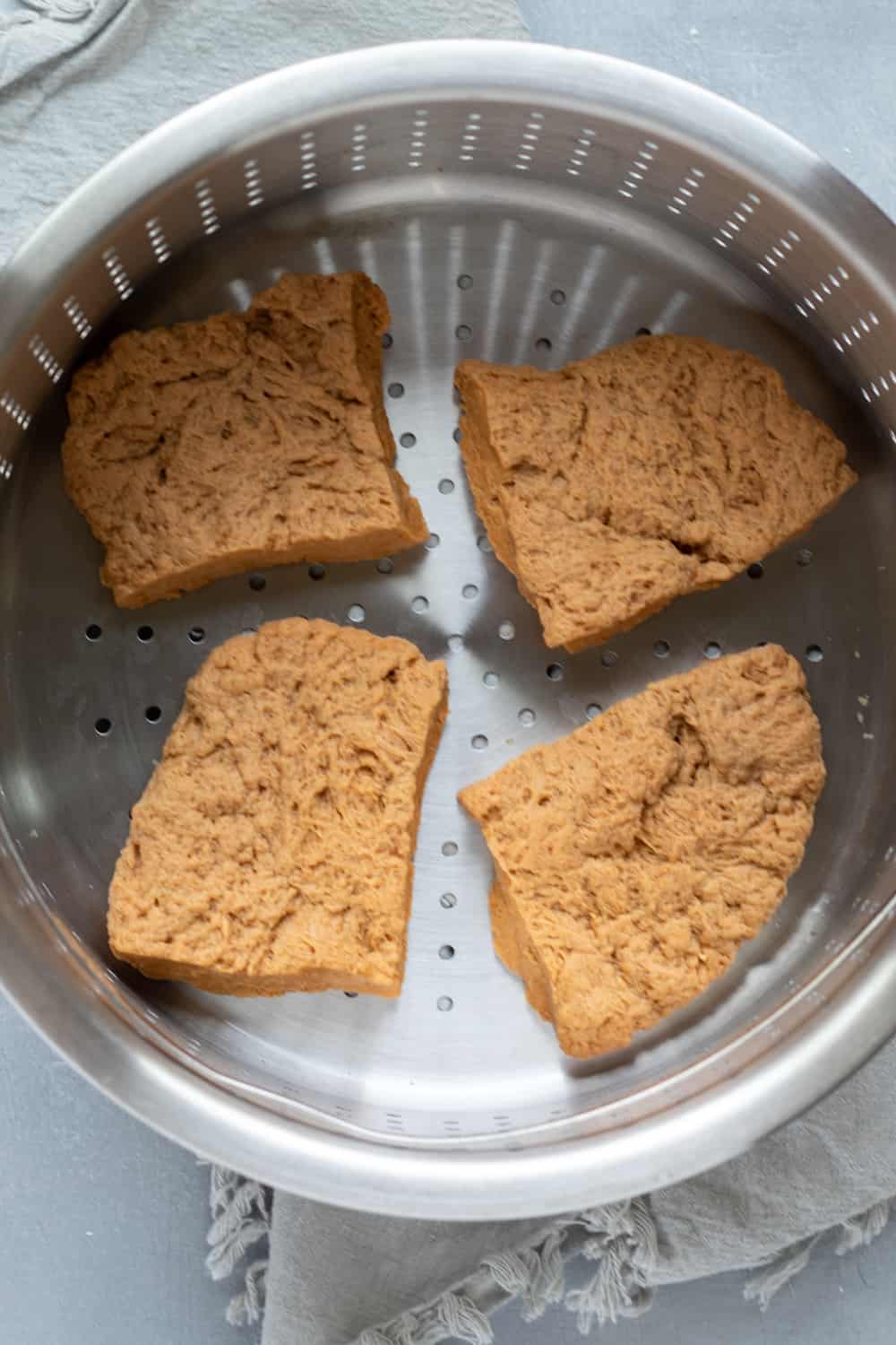 4 pieces of wheat gluten dough in a steamer basket.