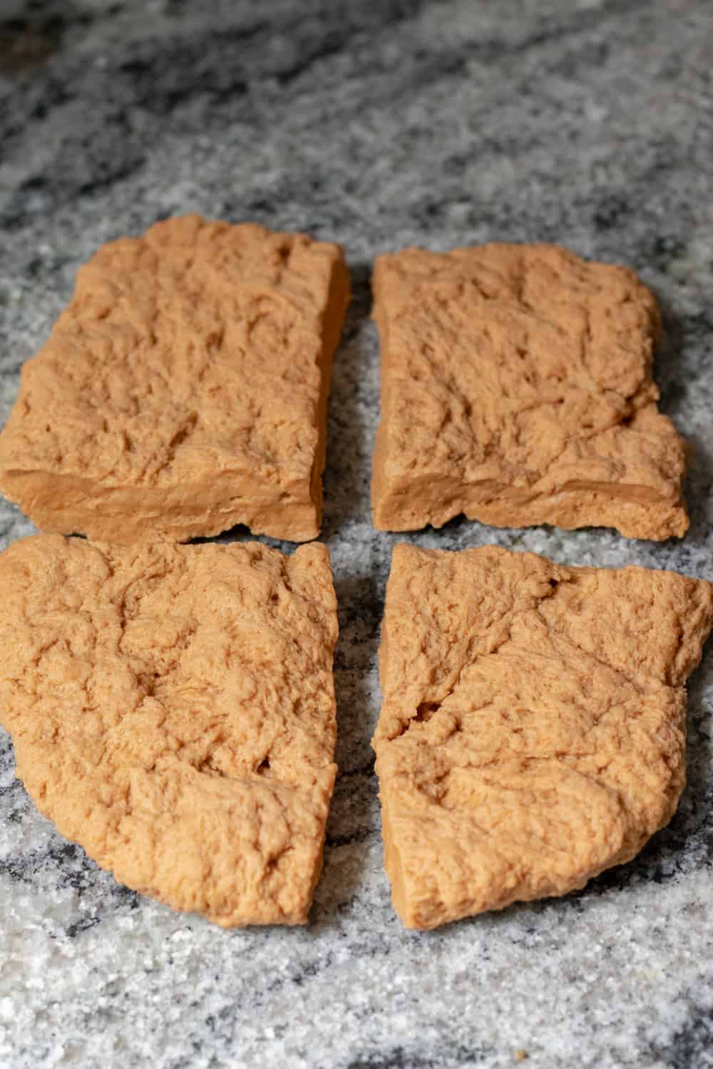 seitan dough cut into four pieces shaped similar to steaks.