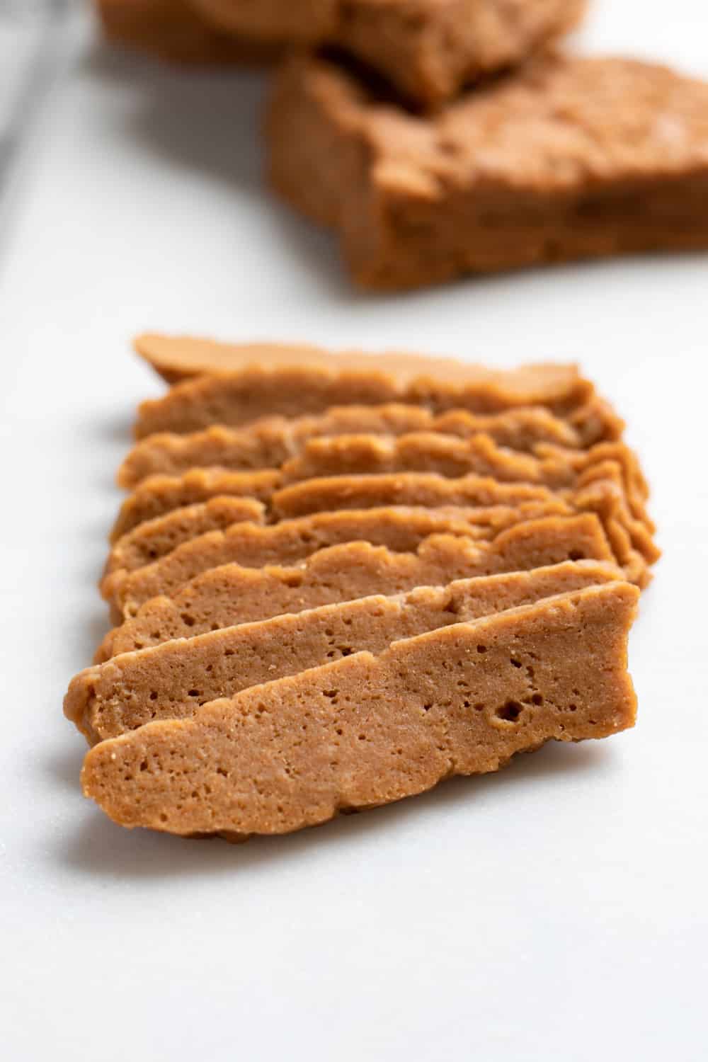 slices of steamed seitan on a white serving board.