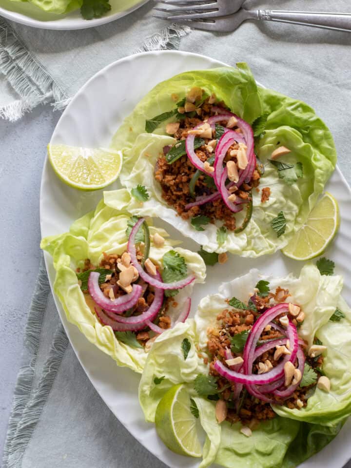 overhead shot of three Thai Larb lettuce cups on a white platter