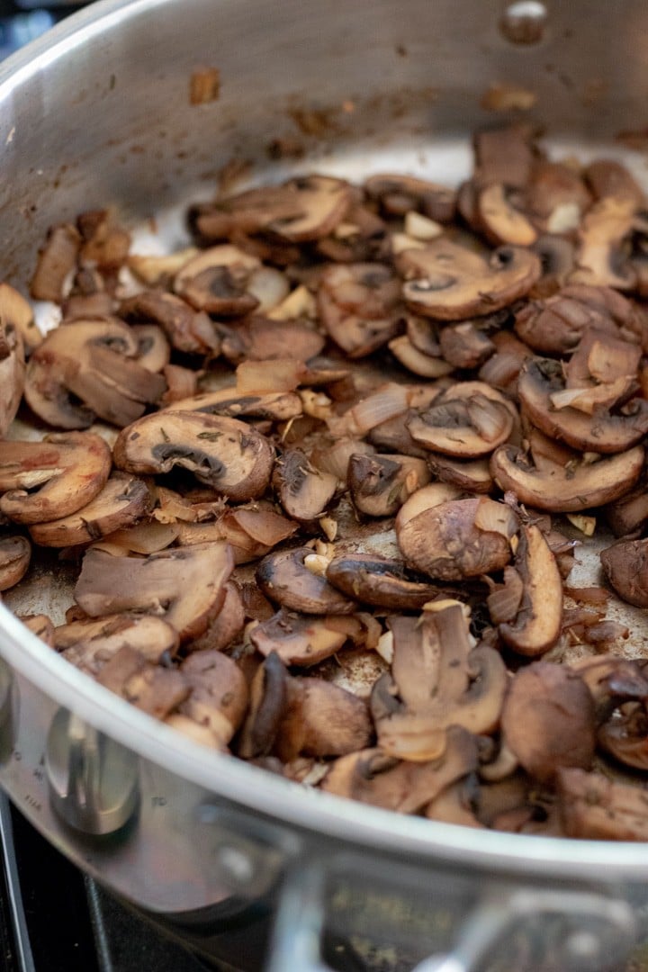 mushrooms sautéing in a pan.