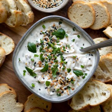 Caramelized Onion Dip on a platter with crackers and bread for dipping.