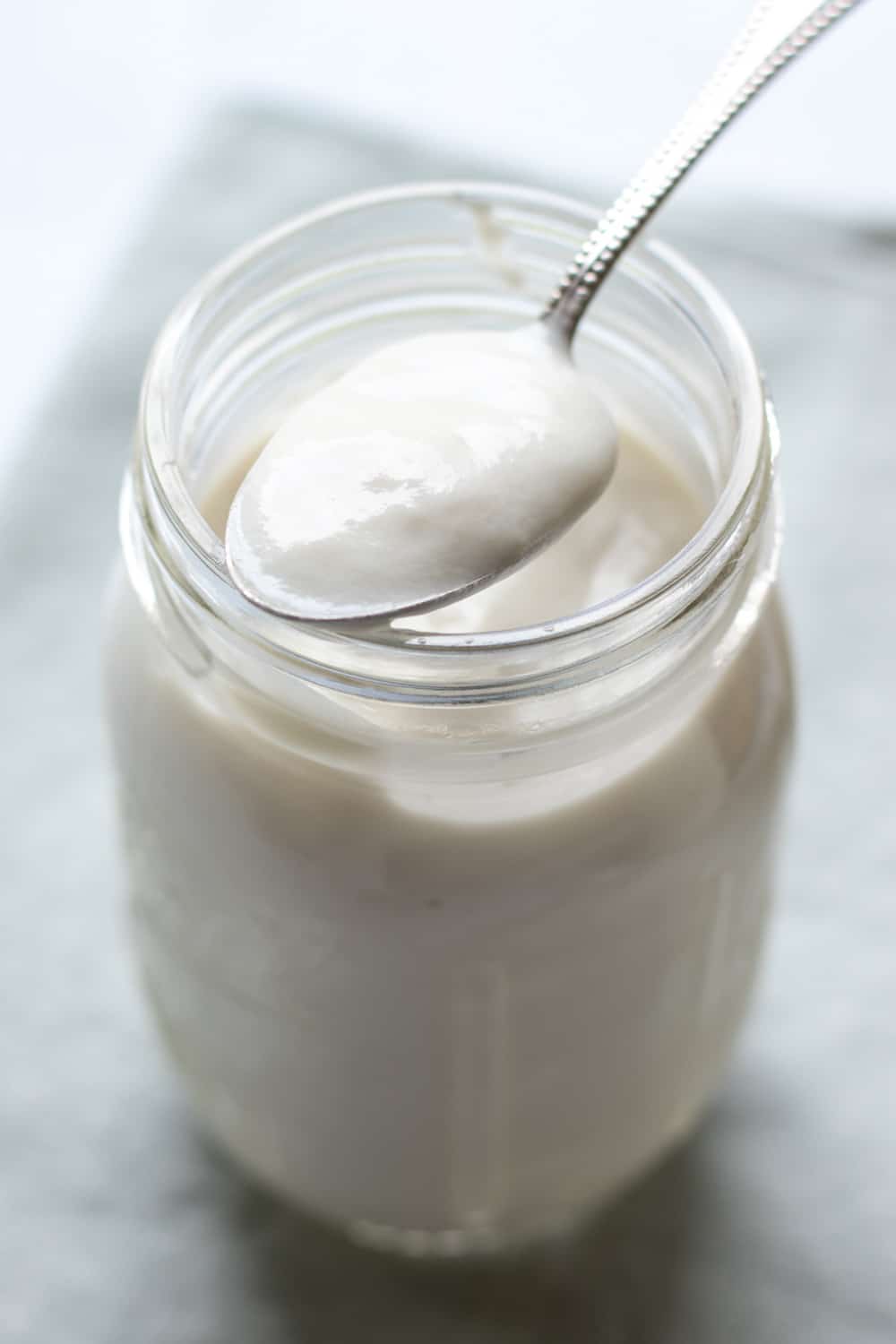 backlit jar and spoonful of cashew yogurt .