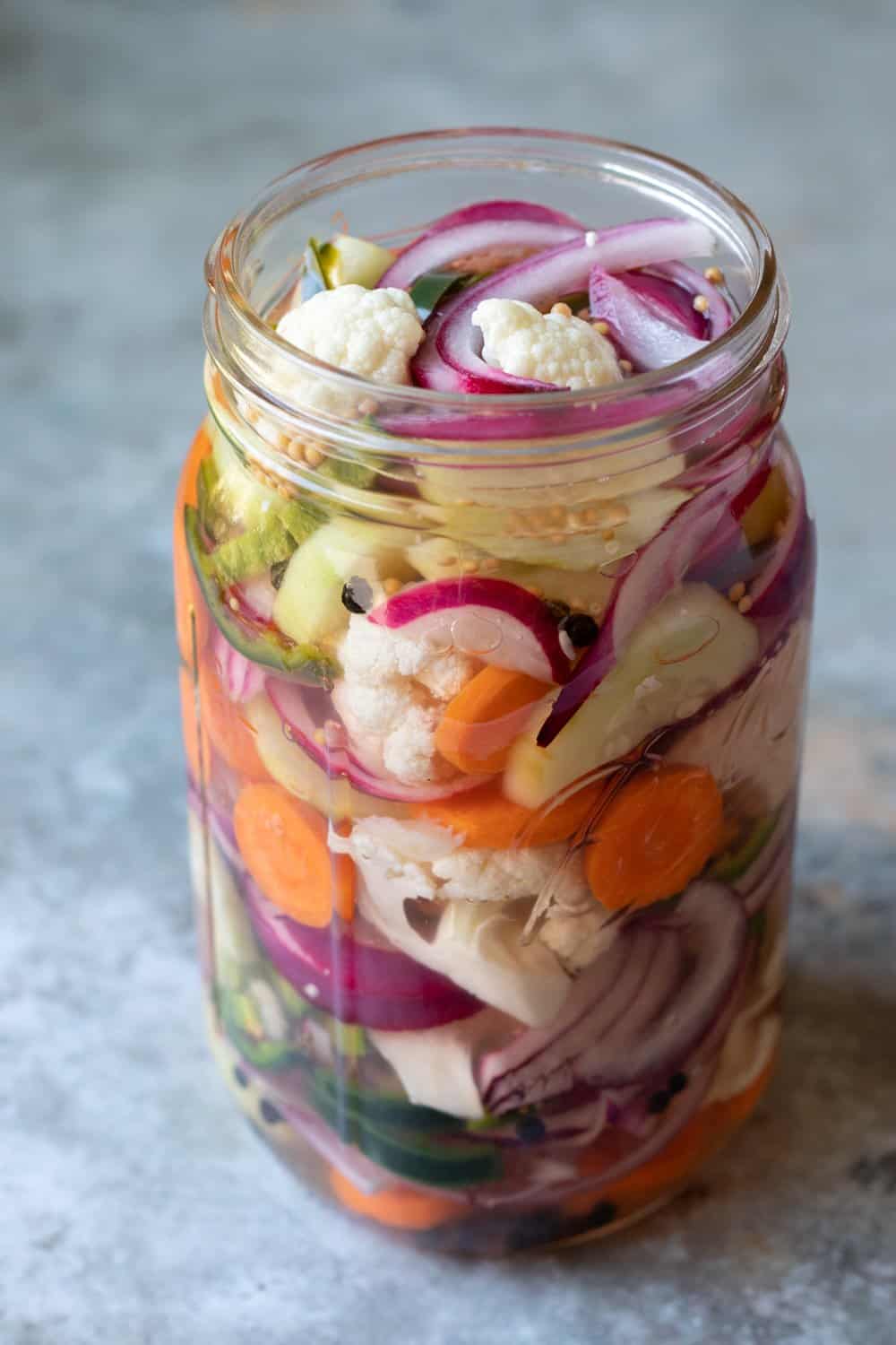Mason jar filled with vegetables and homemade pickling brine.