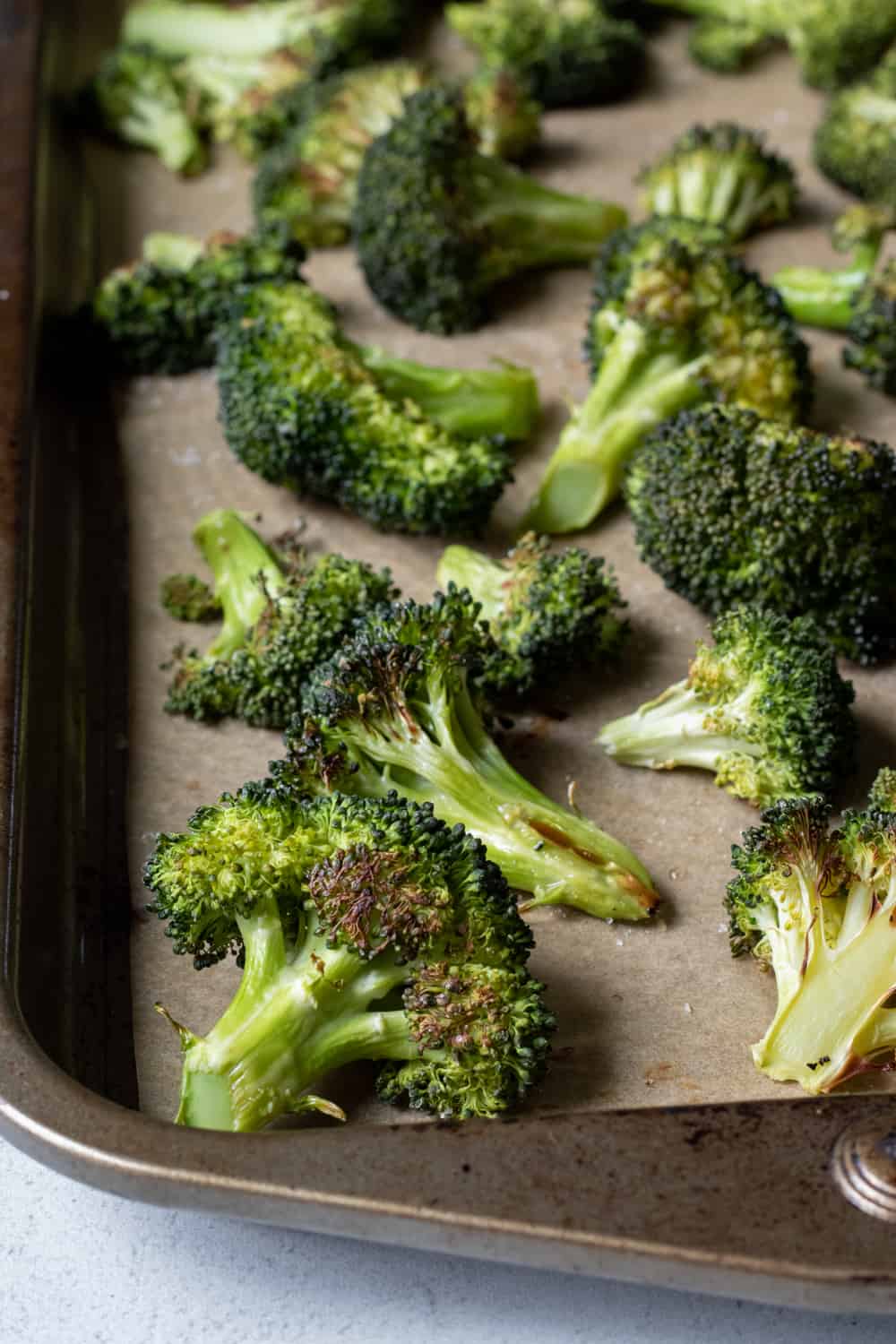 Roasted broccoli on a baking sheet.