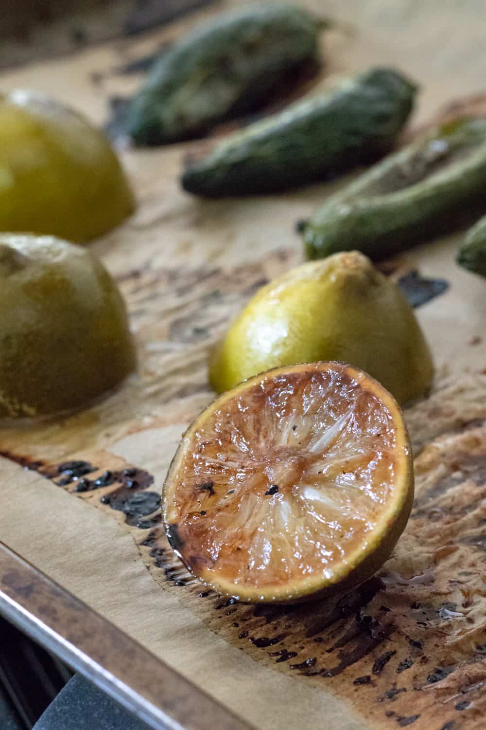 roasted limes and jalapeños on a baking sheet