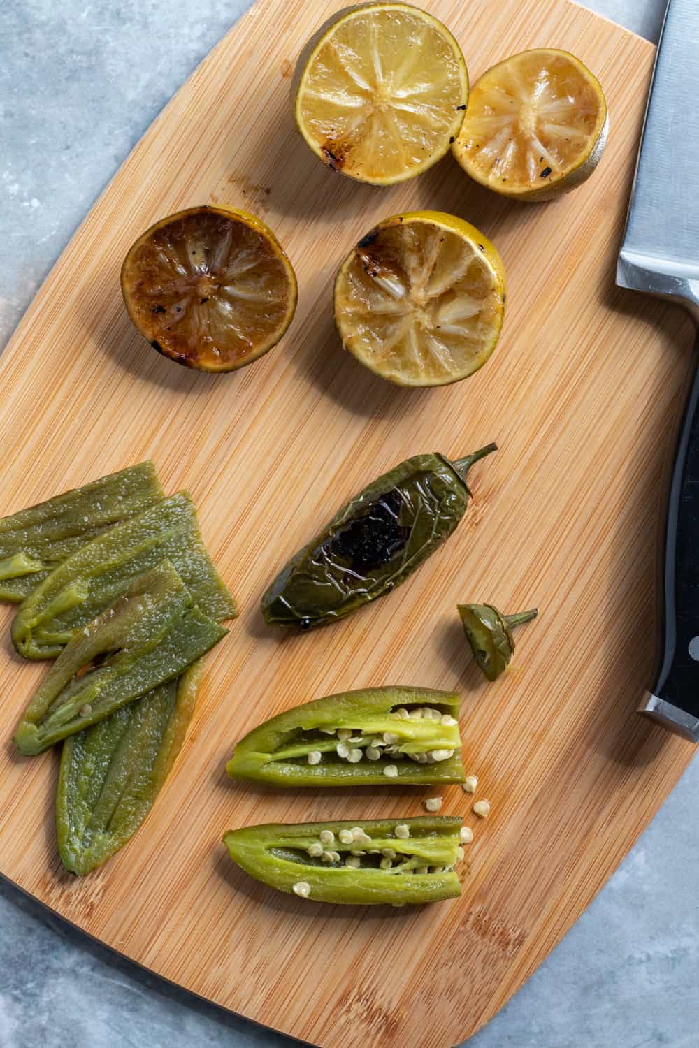 removing skins and seeds from jalapeños on a cutting board