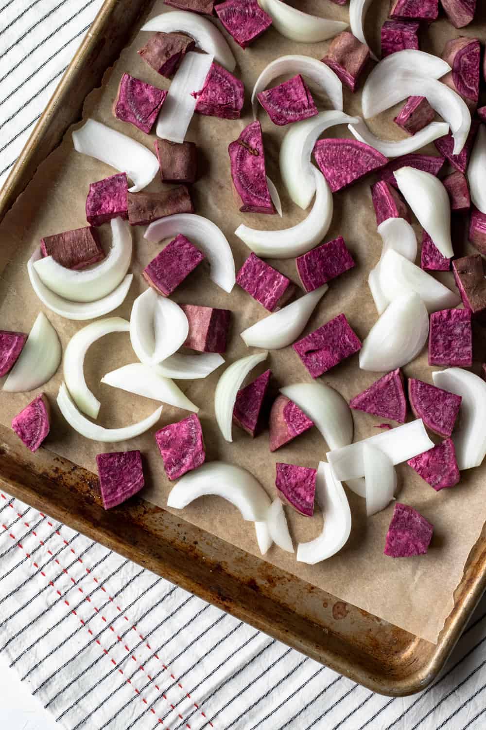 purple sweet potato and onion on a baking sheet.