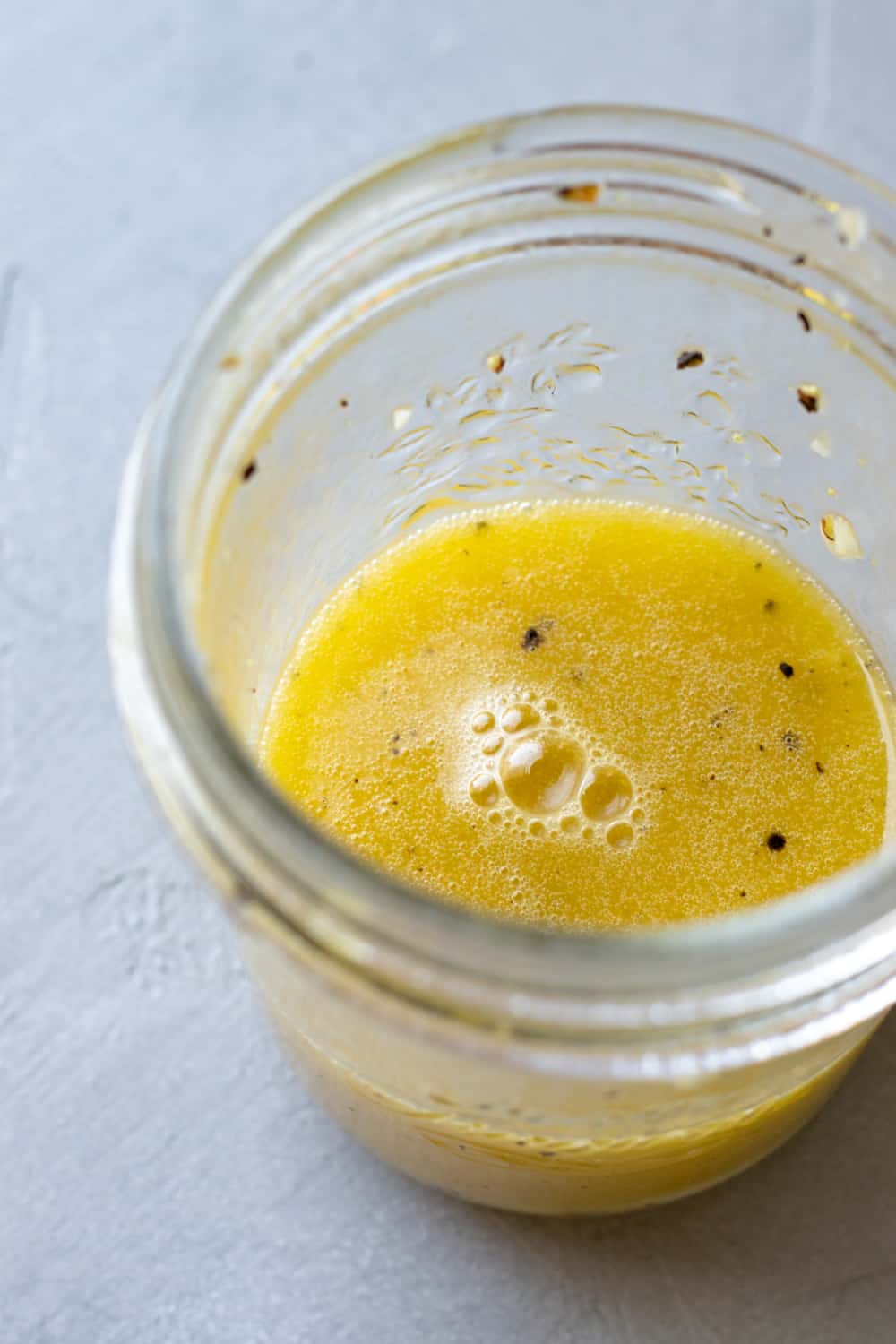 beautiful yellow lemon vinaigrette in a glass jar.