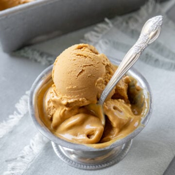 close up of creamy scoops of pumpkin ice cream in a bowl.