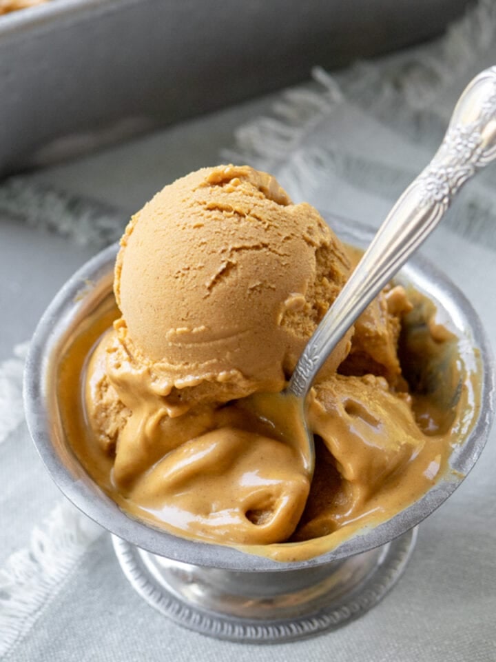 close up of creamy scoops of pumpkin ice cream in a bowl.