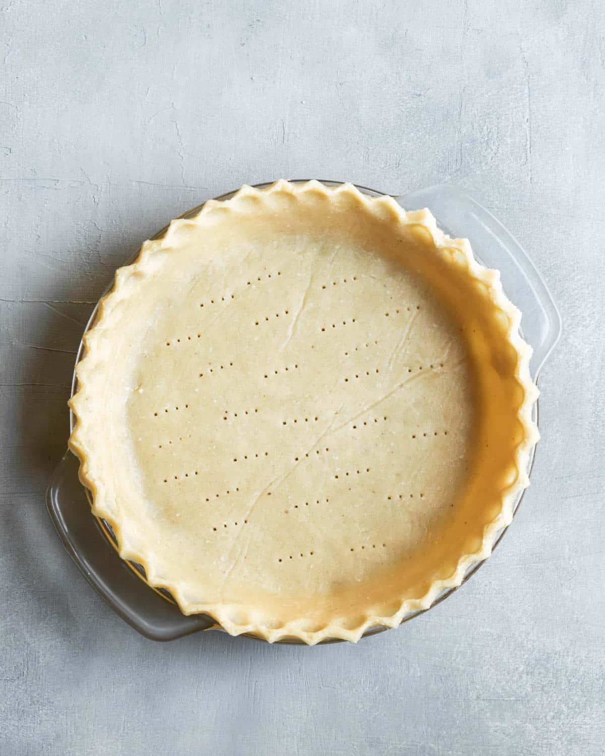 unbaked pie crust with decorative edges.