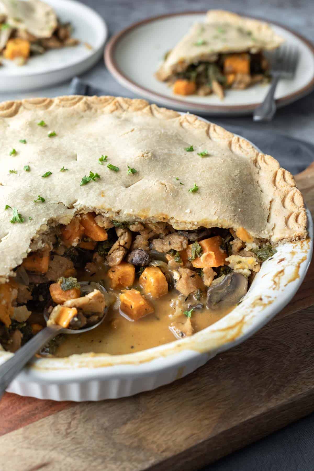 Veggie pot pie with several servings removed showing the chunky texture inside.