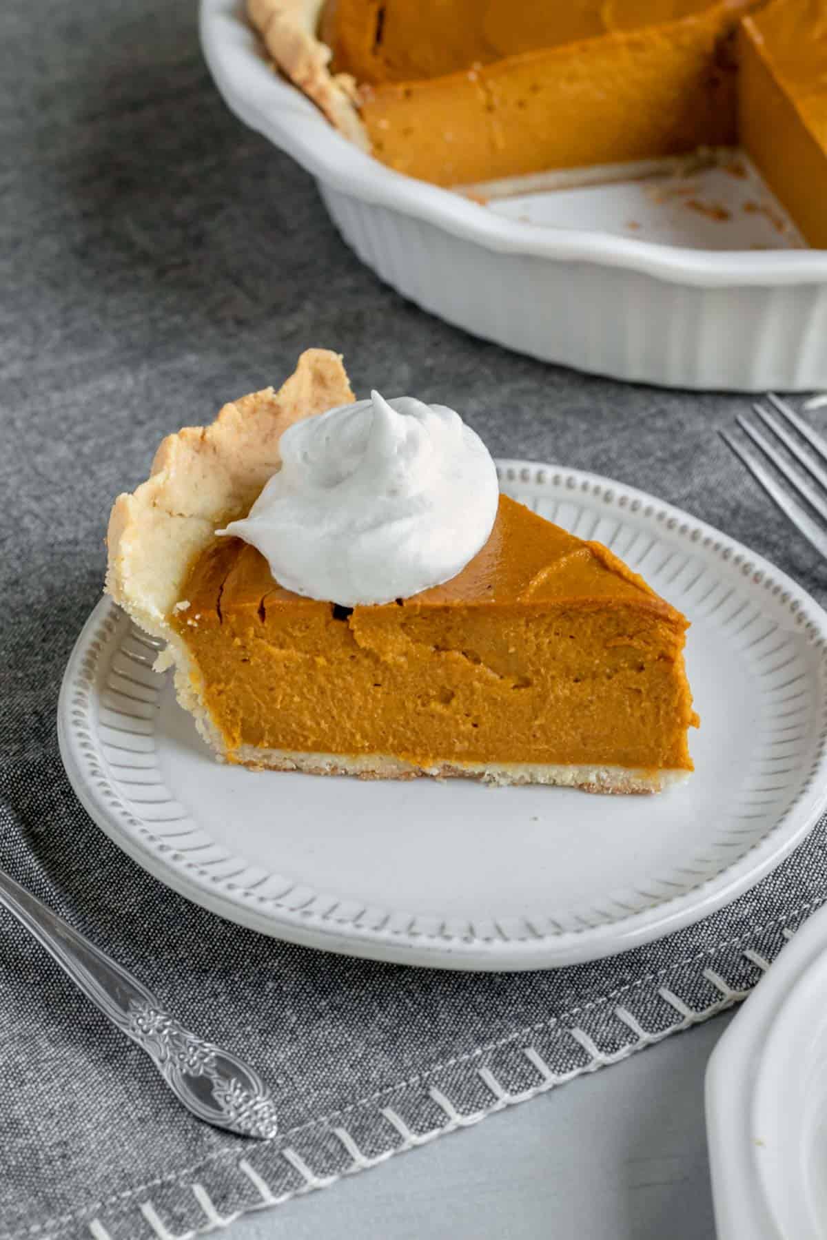 deep dish vegan pumpkin pie topped with So Delicious coconut whipped topping.