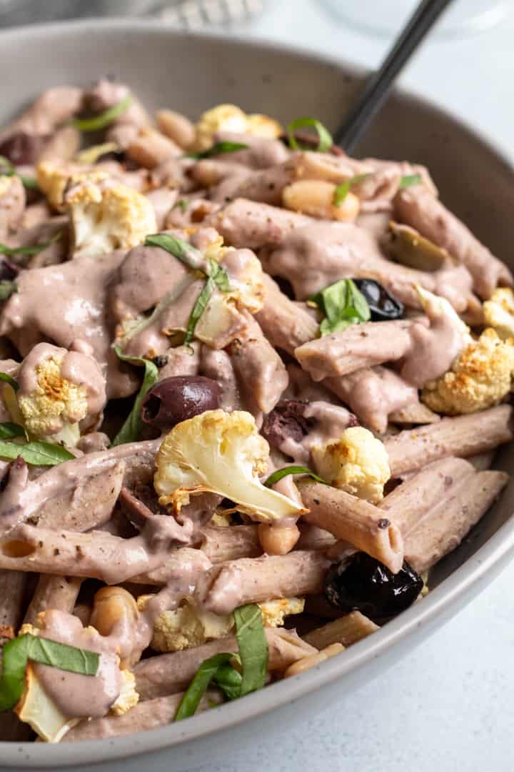 whole-food plant-based olive pasta with roasted cauliflower in a serving bowl.