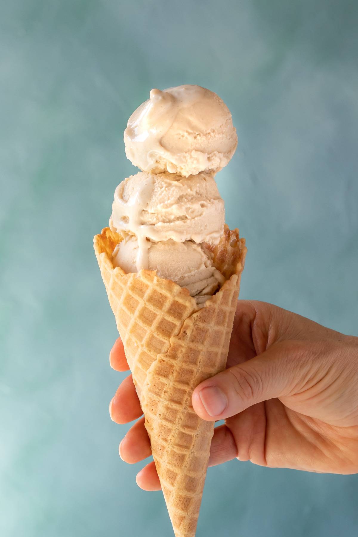 3 scoops of Vegan Vanilla-Maple Ice Cream in a waffle cone.