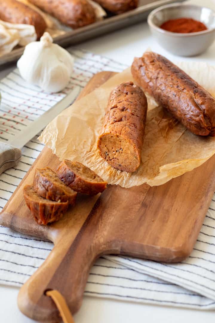 side view of sliced seitan sausage on cutting board.