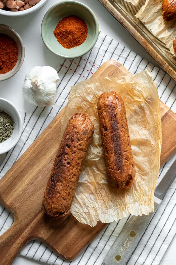 seitan sausages on a cutting board surrounded by spices.