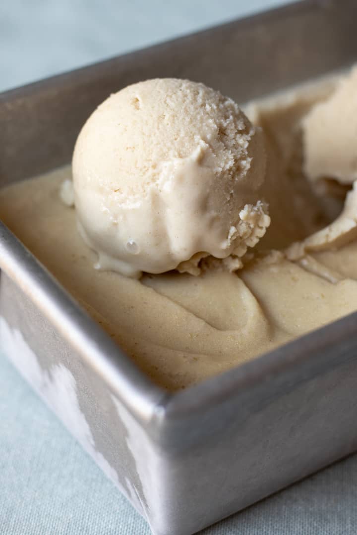 Close up of a scoop of vegan vanilla ice cream made with oat milk and oats.