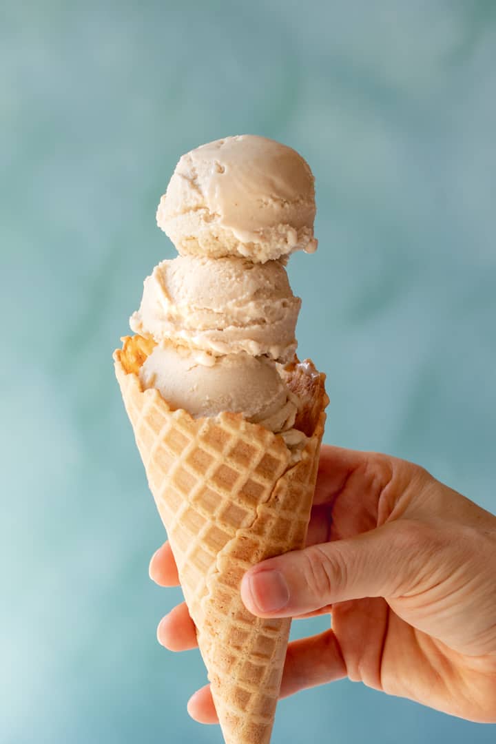 three scoops of Vegan Ice Cream in a waffle cone.