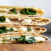 close up side view of sliced quesadillas with spinach. and homemade vegan cheese.