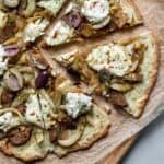 close up of sliced pizza topped with vegan ricotta, sausage, fennel and onion.
