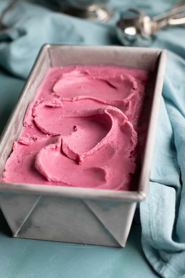 dairy-free ice cream chilling in a loaf pan with ice cream scoop in background.