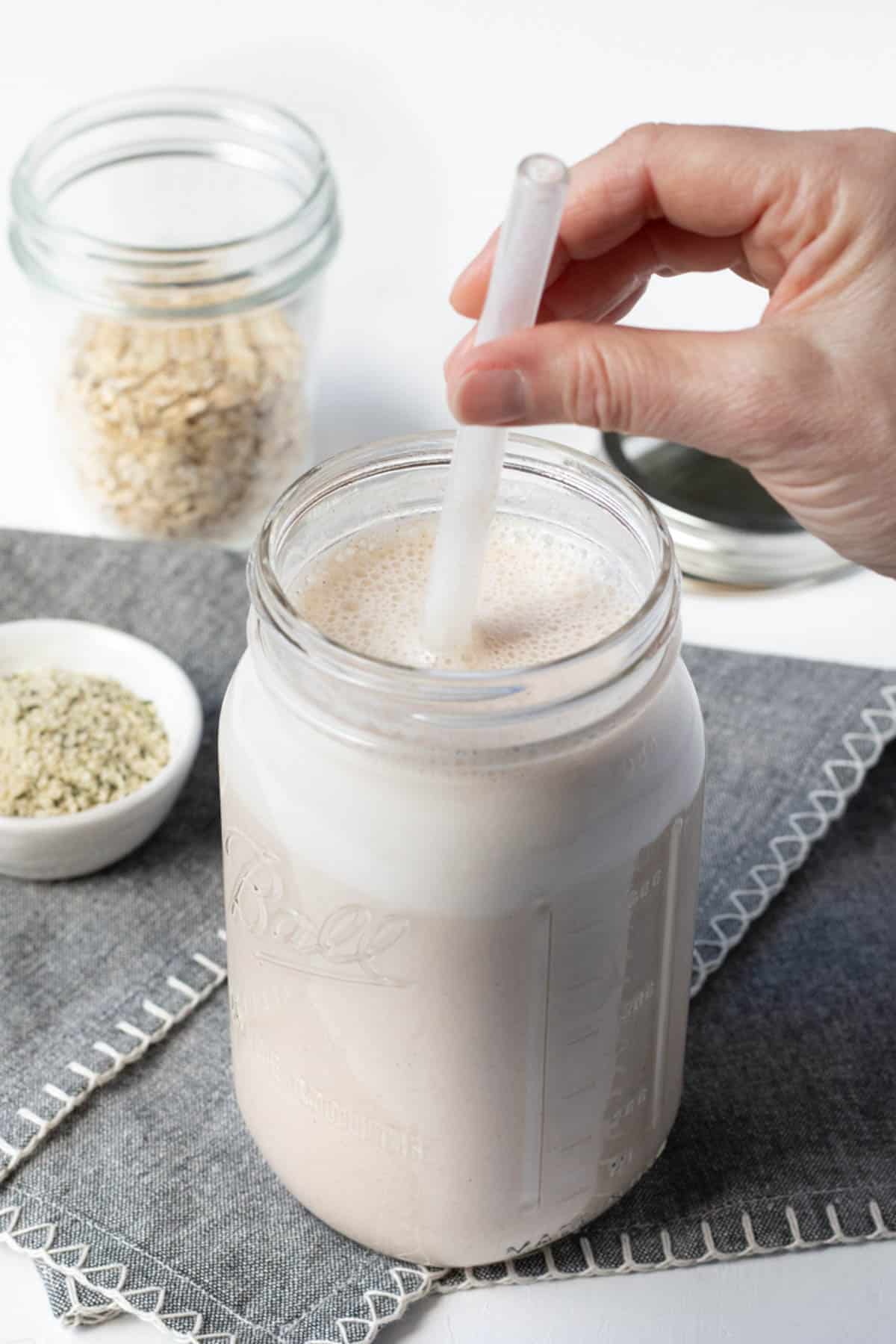 Blended oat and hemp smoothie in a large glass jar.