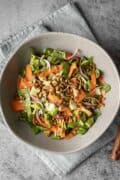 Bok choy salad tossed with dressing in a large serving bowl.