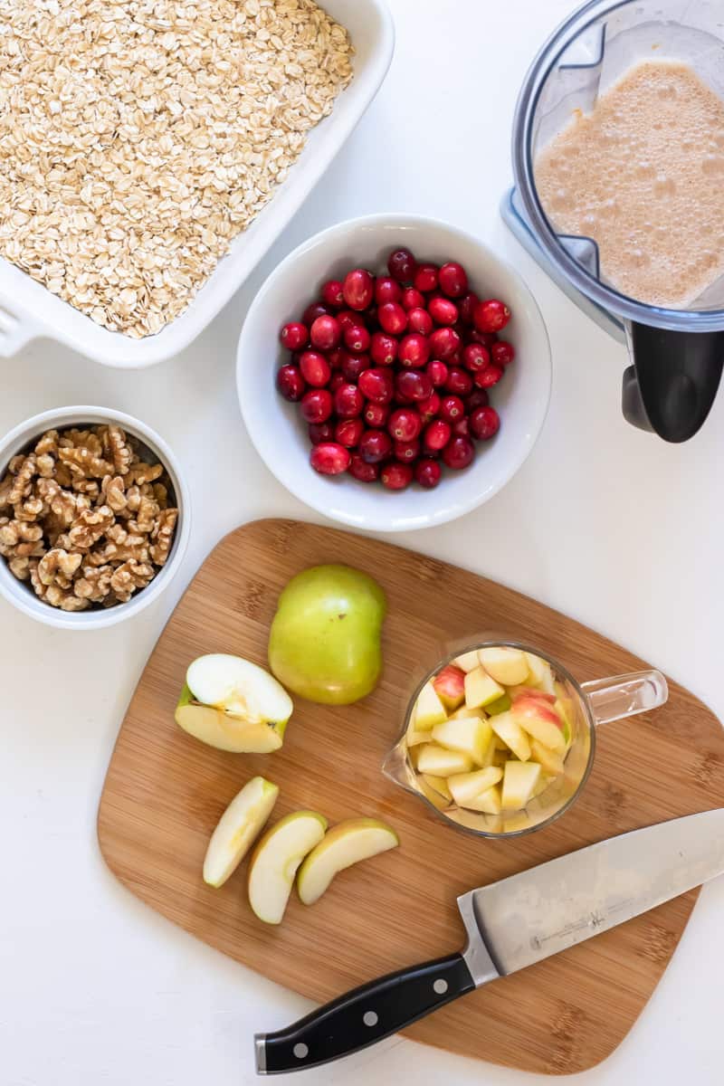 ingredients needed for vegan apple baked oatmeal with chopped apple on a cutting board.