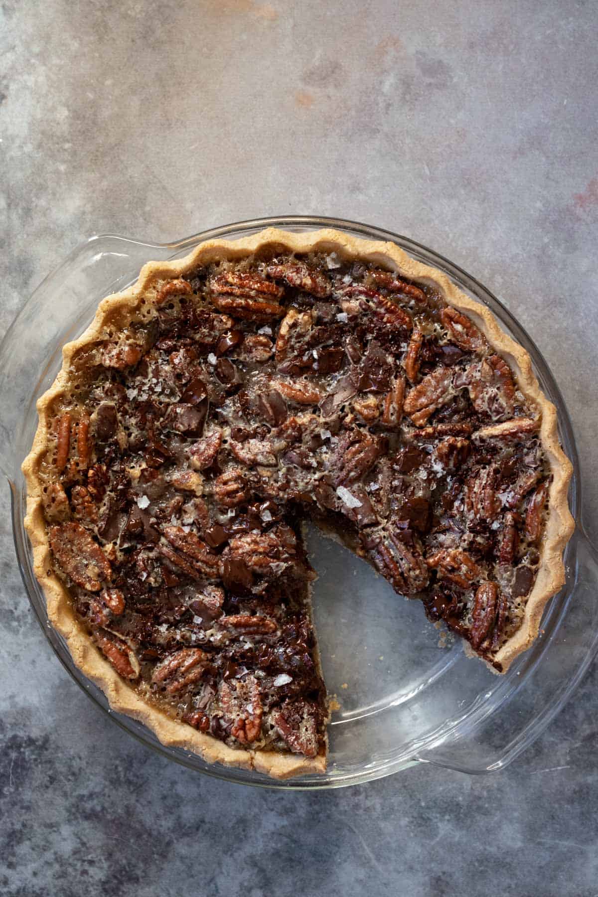 vegan chocolate pecan pie in a glass pie plate.