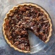 overhead view of chocolate pecan pie with one slice removed.