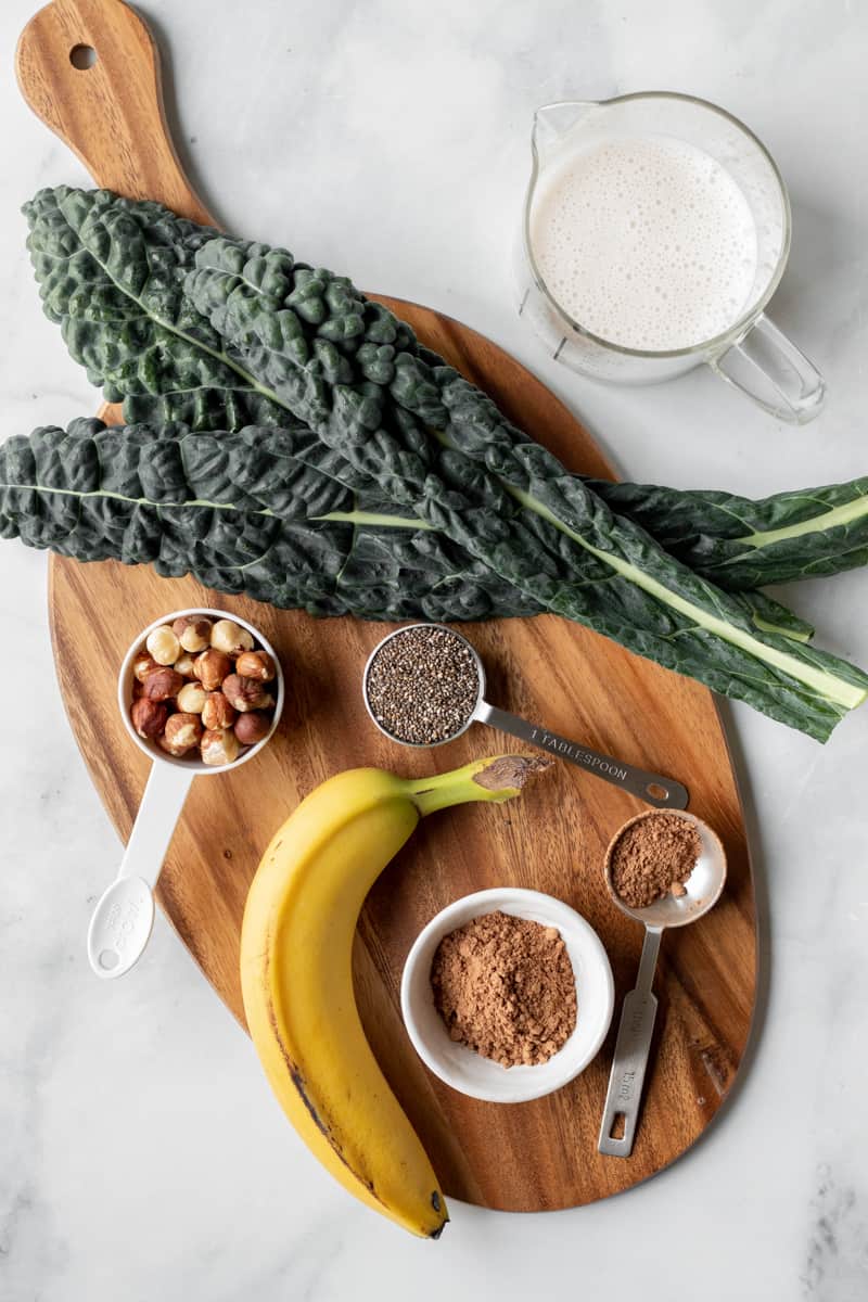 Chocolate kale smoothie ingredients laid out on a board.