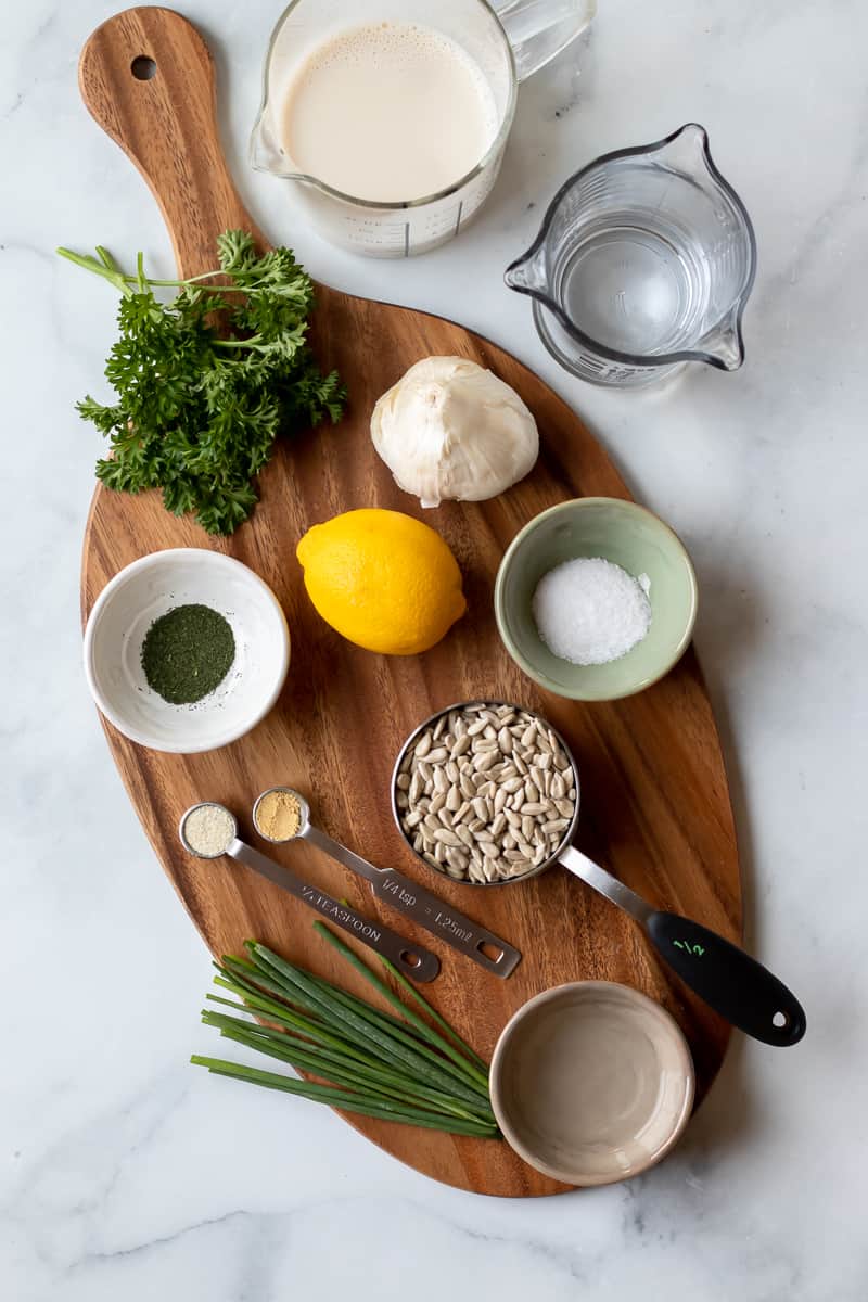 Ingredients for nut-free vegan ranch laid out on wood board.