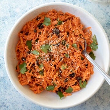 overhead view of carrot salad in large white serving bowl.