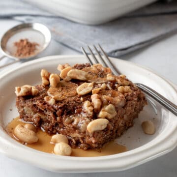 baked oatmeal on a white plate drizzled with maple syrup