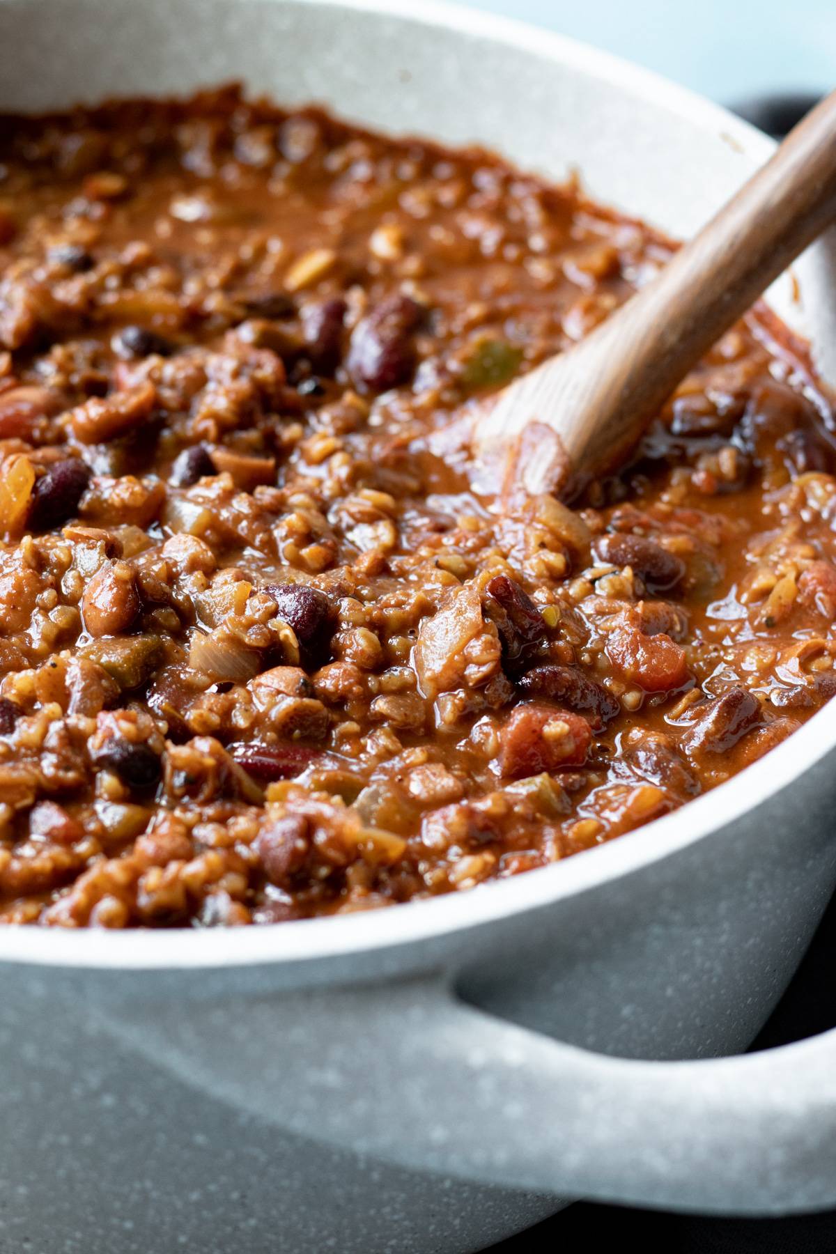 close up of red lentil chili with bulgur and 3 types of beans.