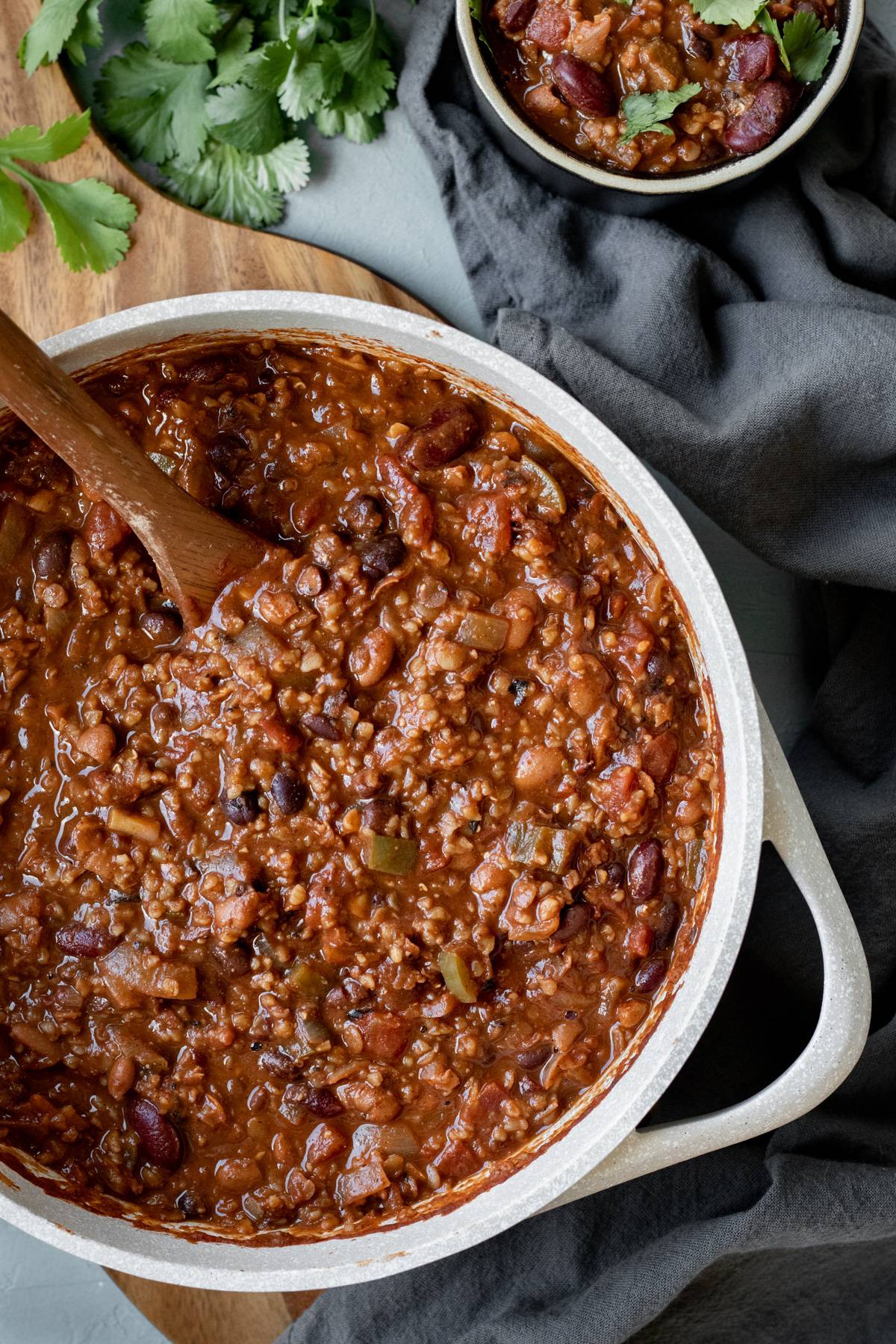 a big pot of vegan chili with a cup of chili on the side.