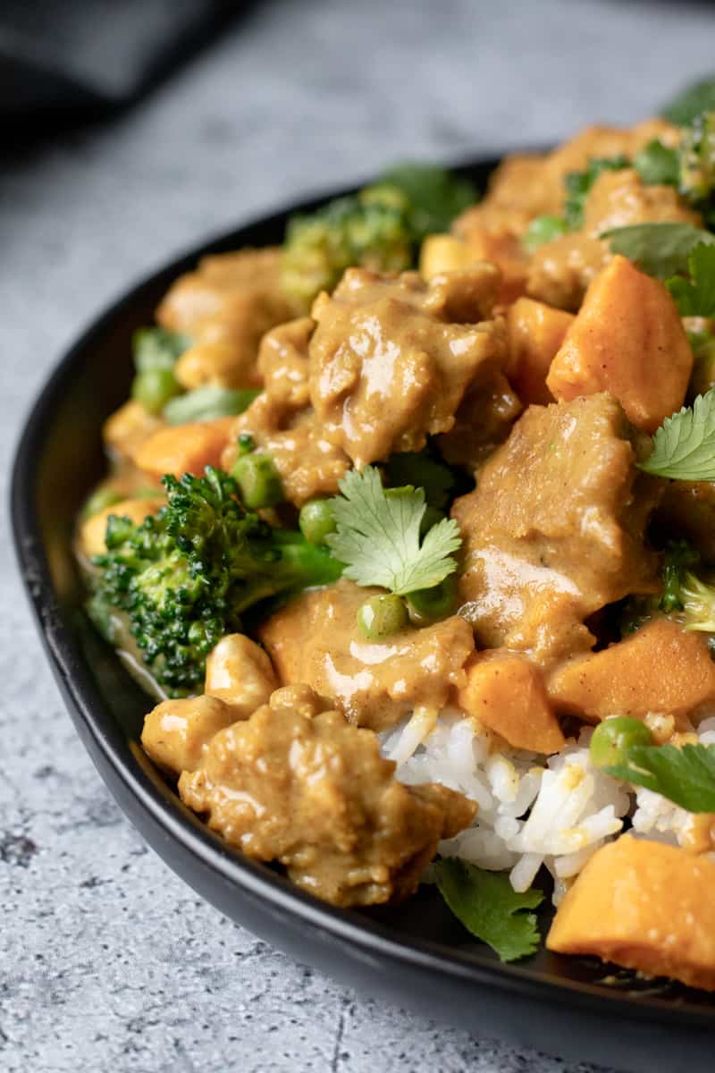 close up of Massaman Curried Seitan on a black plate.