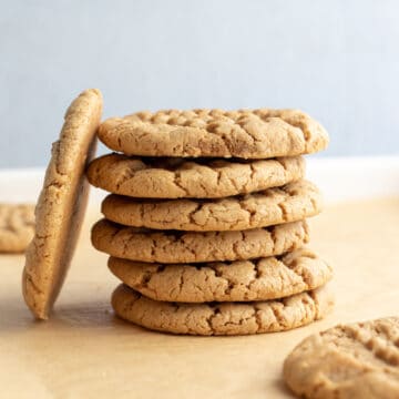 a stack of 6 cookies with one cookie leaning against the side