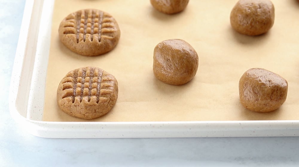 balls of peanut butter cookie dough on a baking sheet.