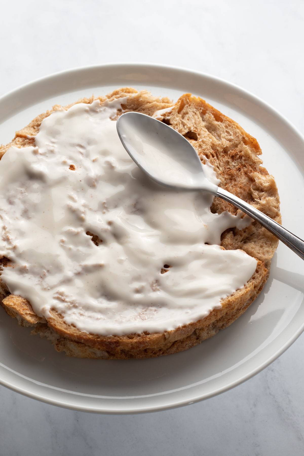 spreading yogurt on one layer of french toast.