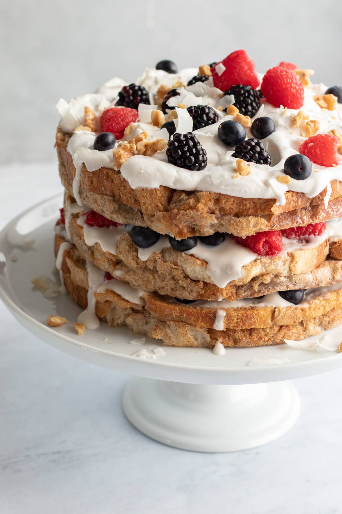 vegan french toast cake on a white cake stand.