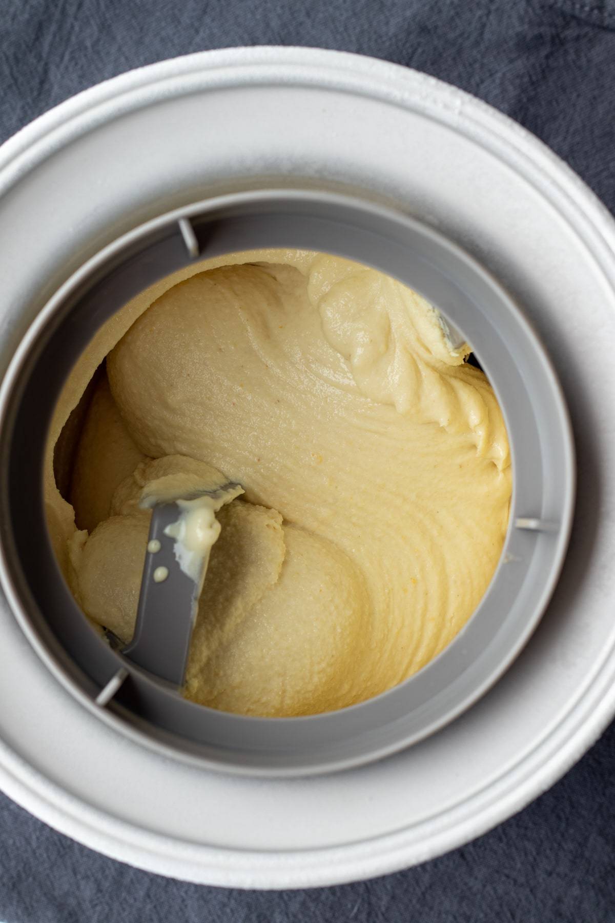 looking inside the ice cream maker full of freshly churned lemon ice cream.