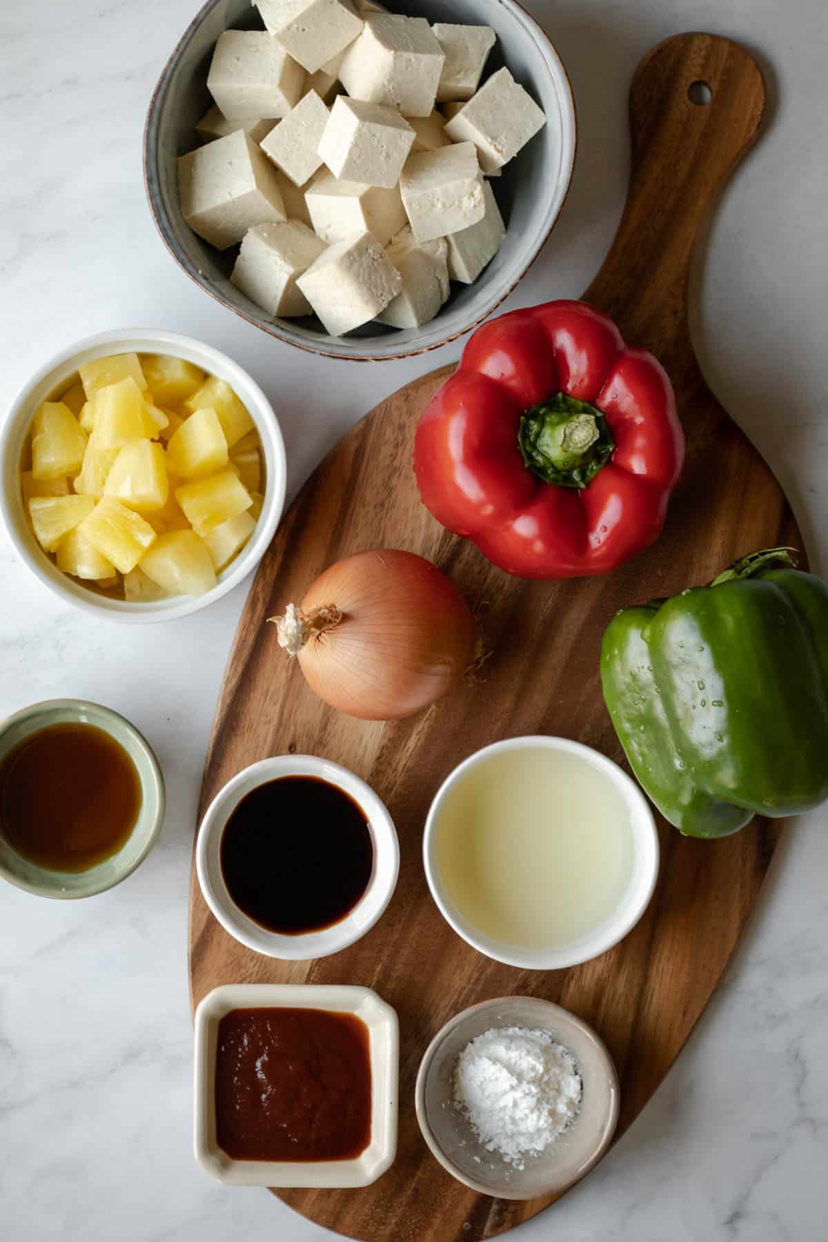 ingredients for sweet and sour tofu laid out on a cutting board.