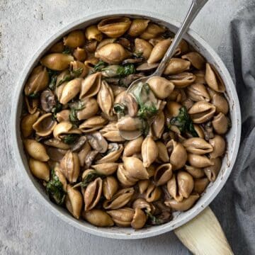 saucy mushroom pasta with spinach in a large pot.