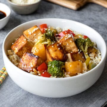 A serving of rice and sweet and sour tofu in a bowl.
