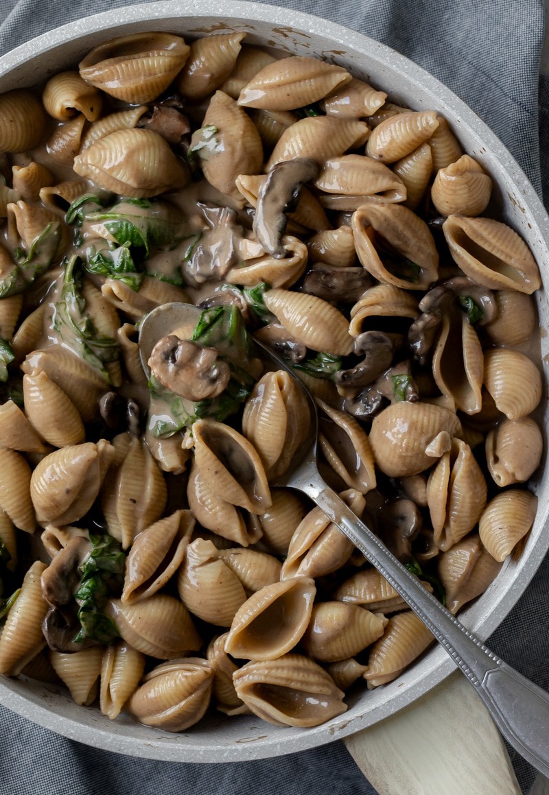 overhead close up of mushroom-colored creamy shells in a pan.