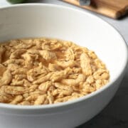 re-hydrating soy curls in a bowl full of broth