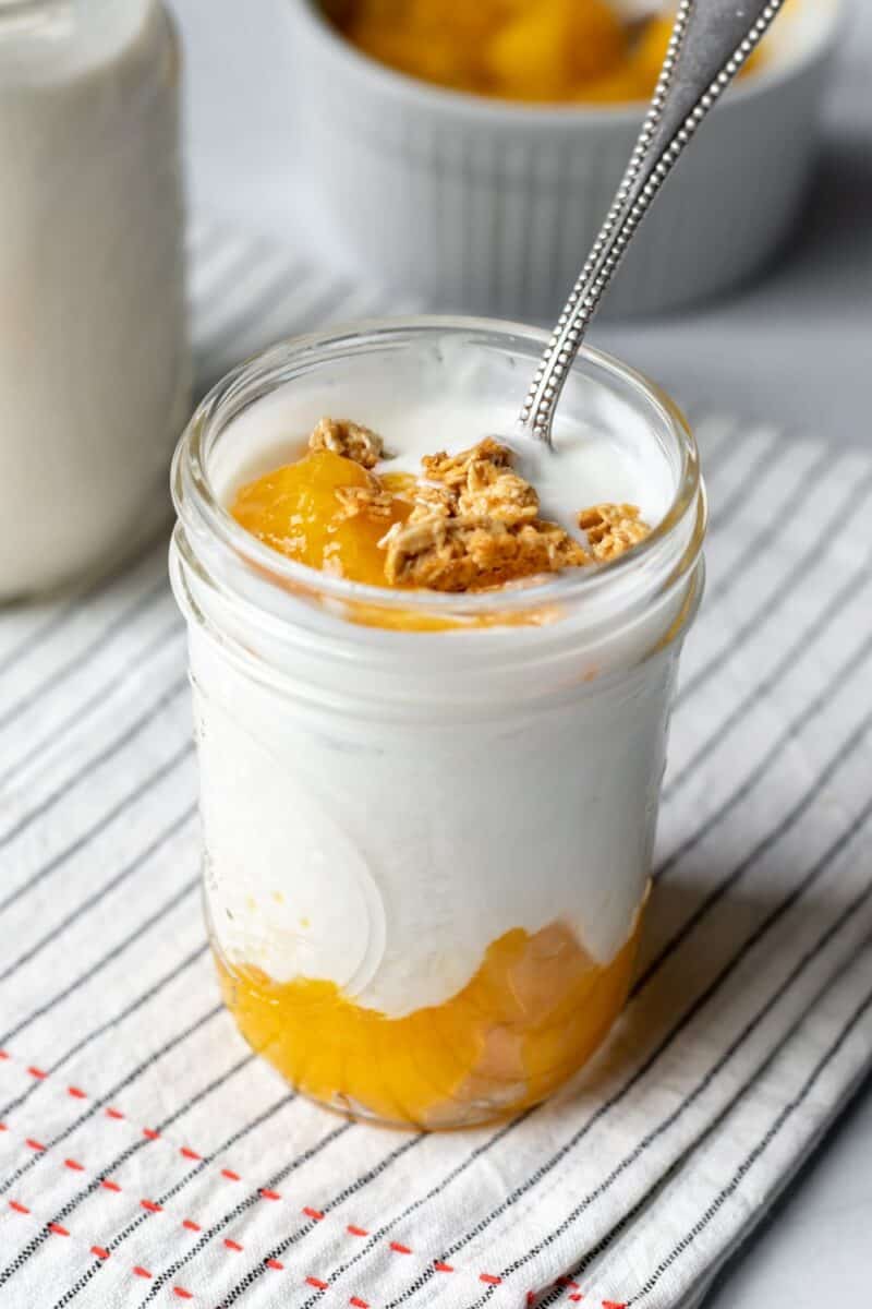 homemade mango compote layered with cashew yogurt in a small jar.